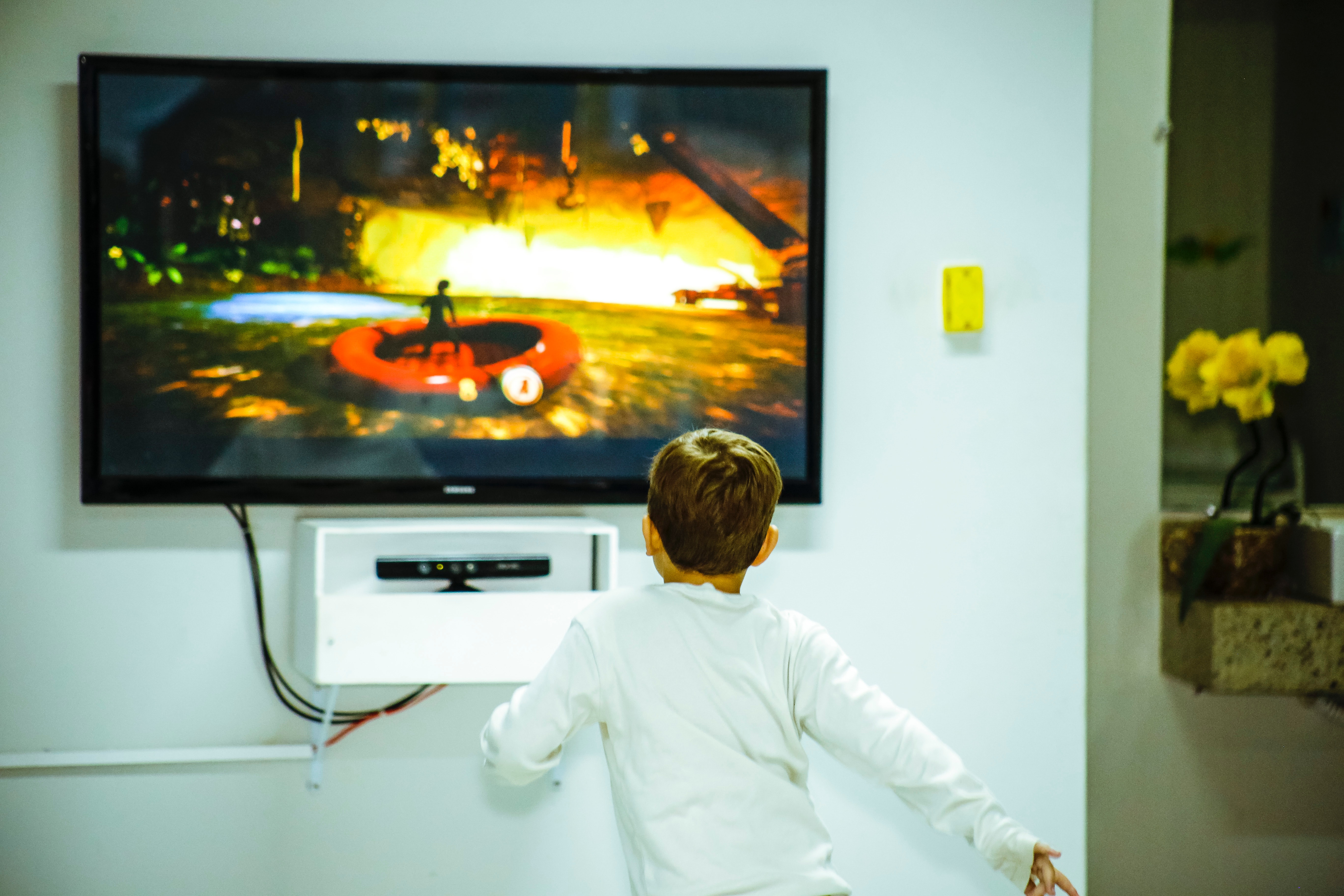 boy-standing-in-front-of-flat-screen-tv-1682519